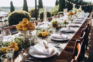 Guests serving themselves from a buffet table and others being served plated meals at a large community event.