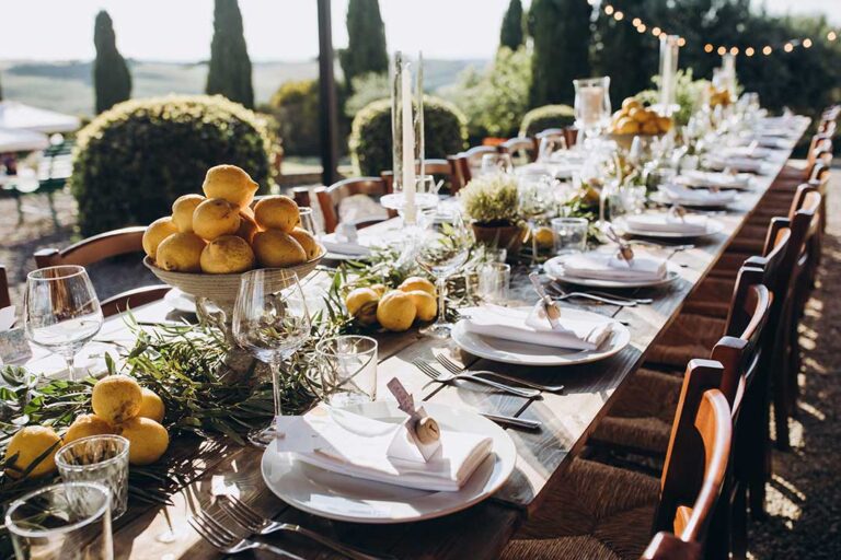Guests serving themselves from a buffet table and others being served plated meals at a large community event.