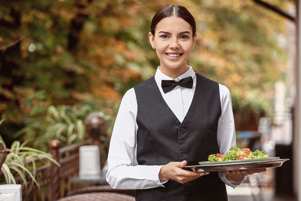 Guests arrange colorful savory bites, skewers, pastries, and fresh appetizers on a home party table.